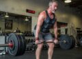 a middle aged man doing deadlifts