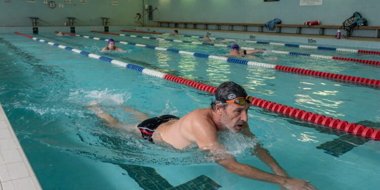 mans winning lengths of the pool to improve his fitness