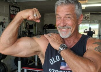 55 year old man showing off his big biceps